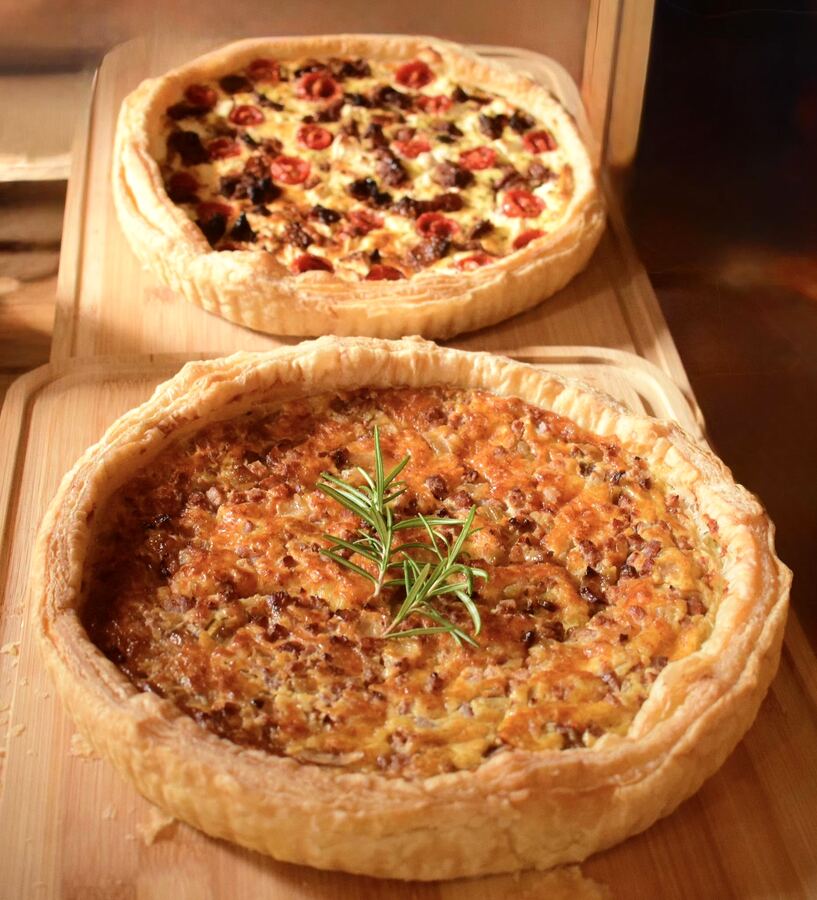 Două quiche-uri întregi, coapte, cu rozmarin deasupra