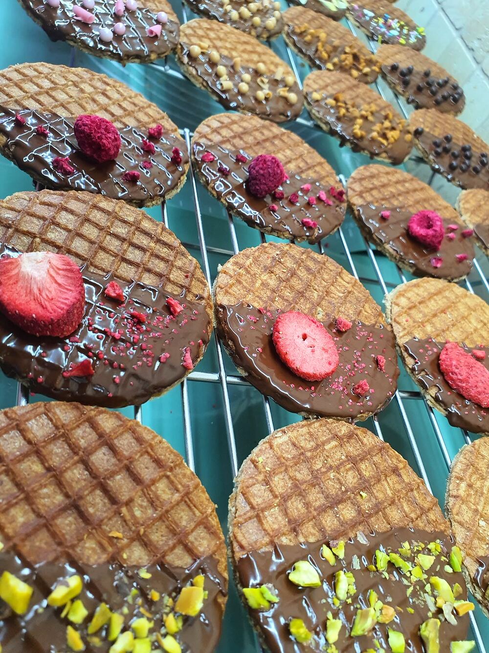 Stroopwafels glazurate cu ciocolată, așezate pe un grătar de patiserie